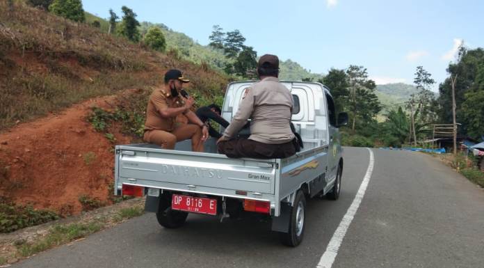 Pakai Mobil Pick Up, Bhabinkamtibmas dan Lurah Keliling Wilayah Berikan Imbauan Prokes Covid-19